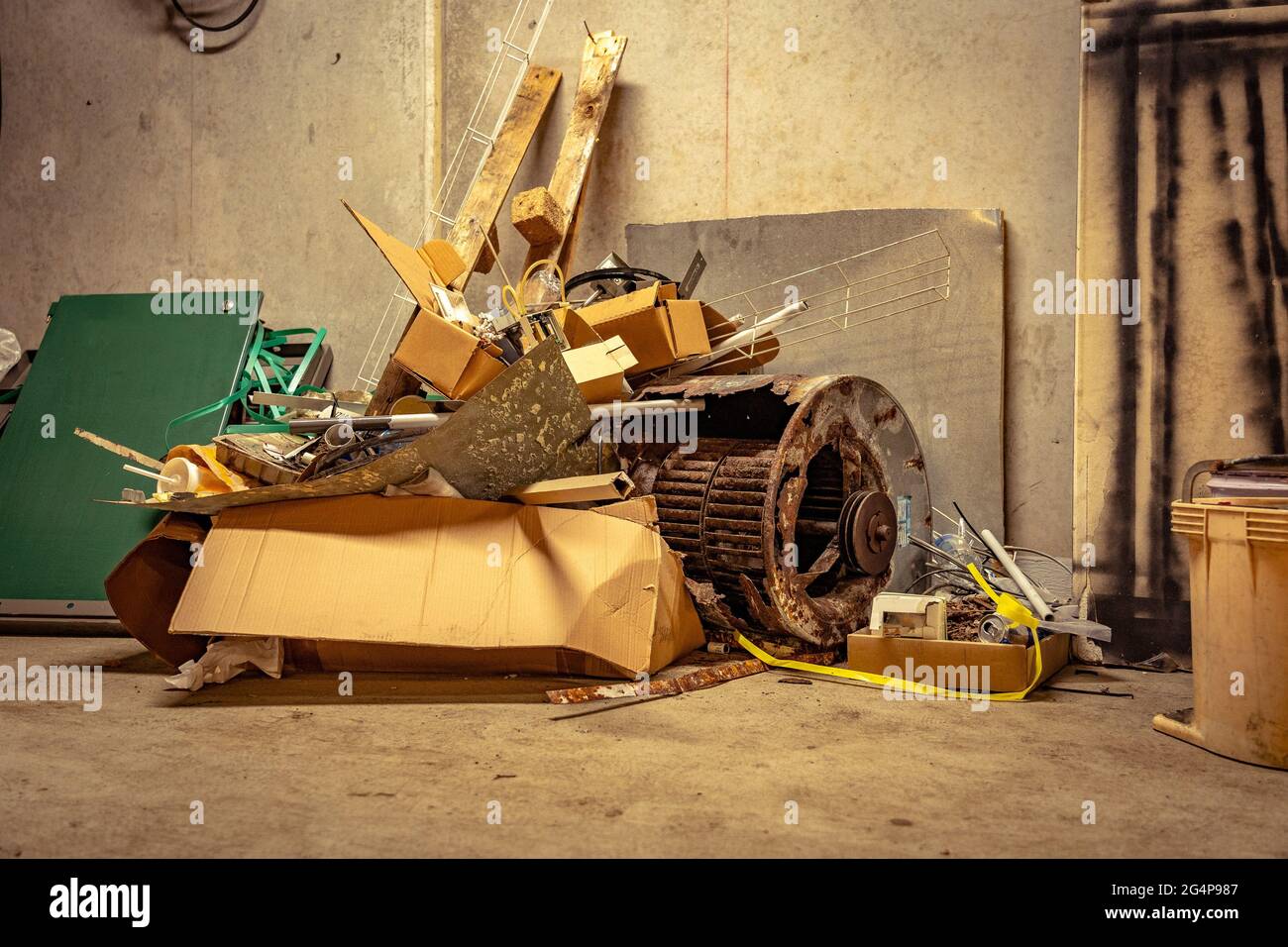 A pile of scrap metal rubbish dumped on the concrete floor Stock Photo