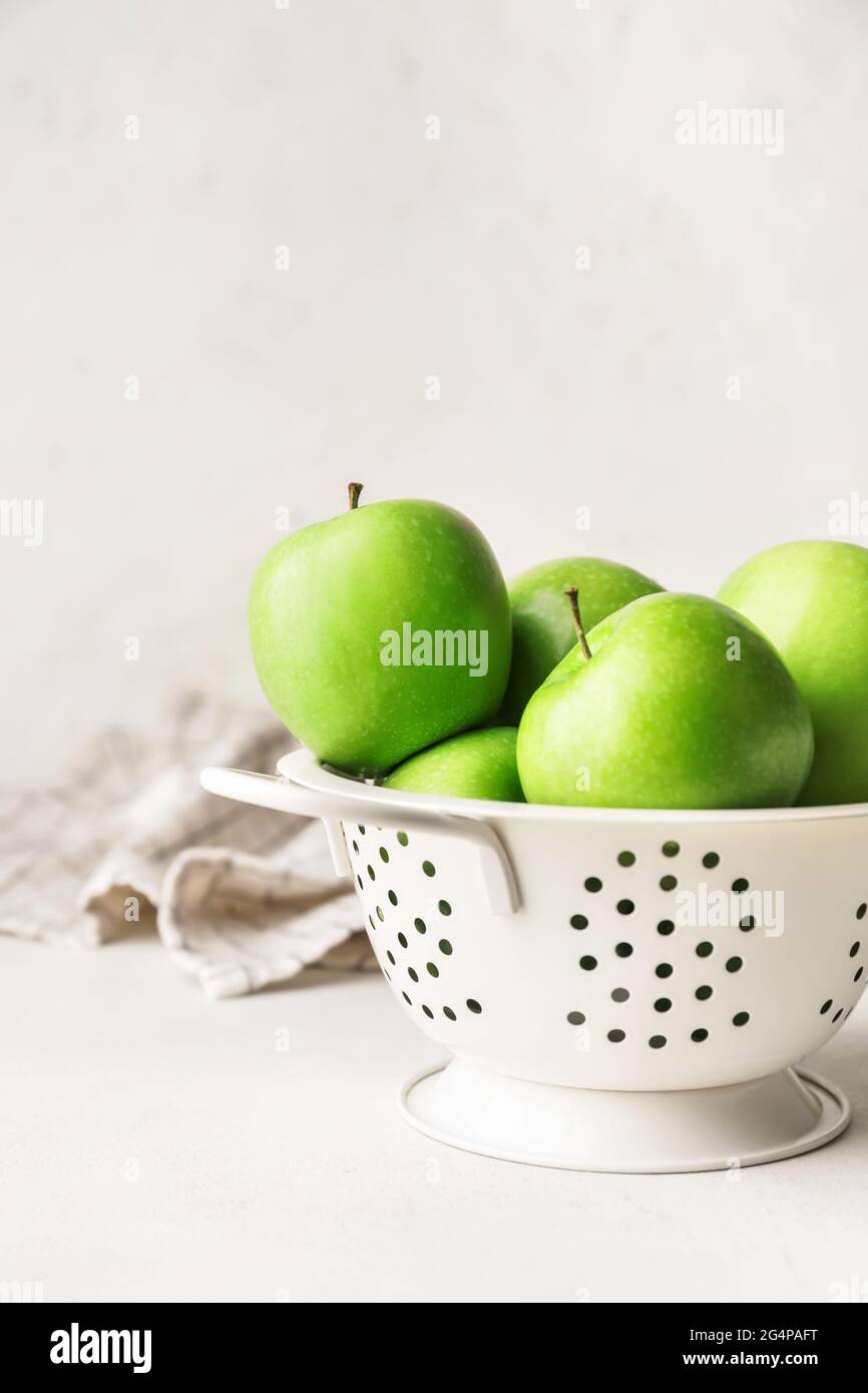 Colander with fresh green apples on table Stock Photo - Alamy
