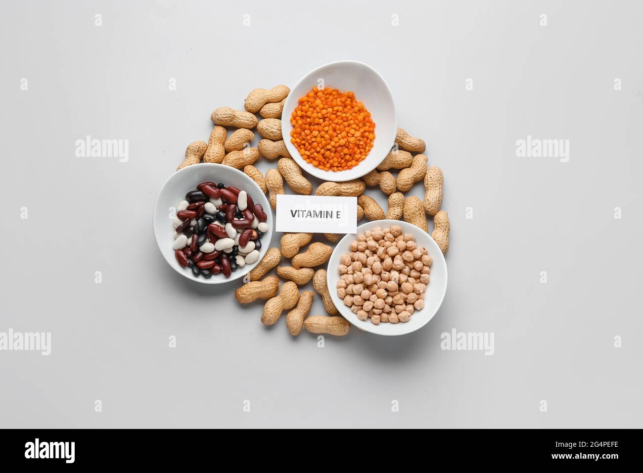 Plates with and different healthy nuts and beans rich in vitamin E on light background Stock Photo