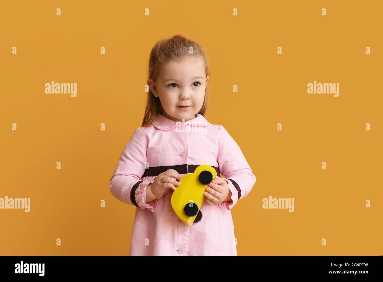 Cute little girl with toy car on color background Stock Photo - Alamy