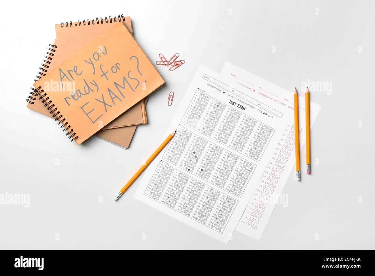 Stationery, answer sheets and notebook with text ARE YOU READY FOR EXAMS? on light background
