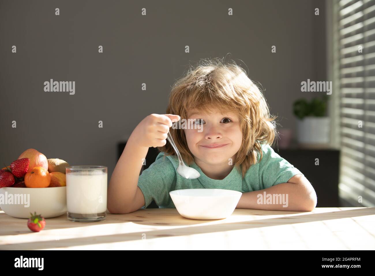 Child eating healthy food. Cute little boy having soup for lunch. Stock Photo