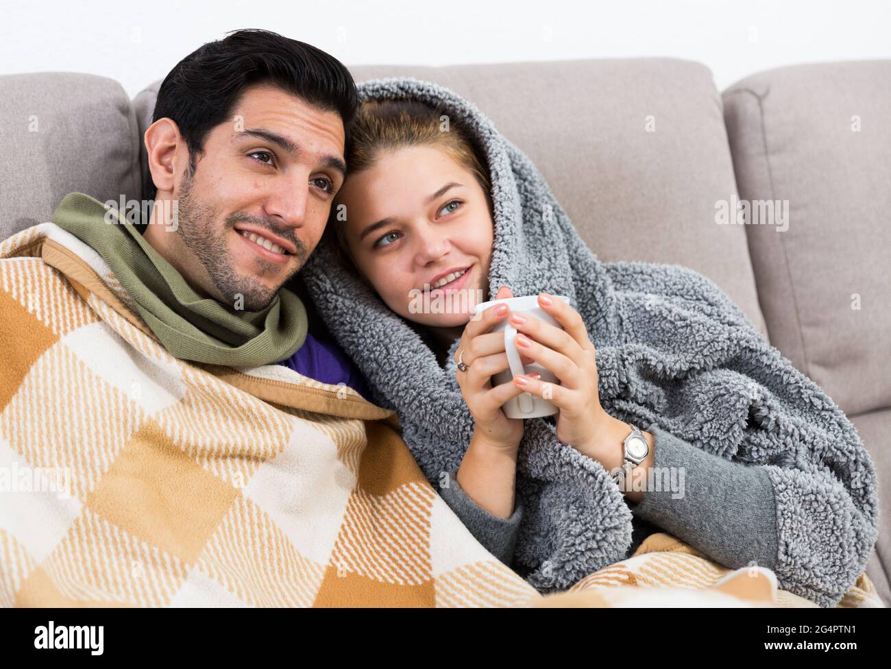 Couple together under blanket watching TV Stock Photo Alamy