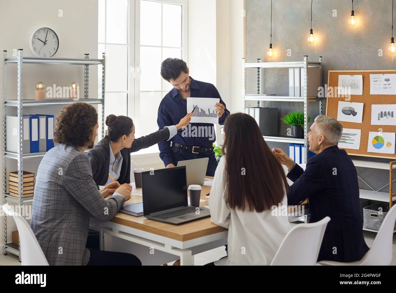 Business team analyzing income charts and graphs during meeting in office Stock Photo