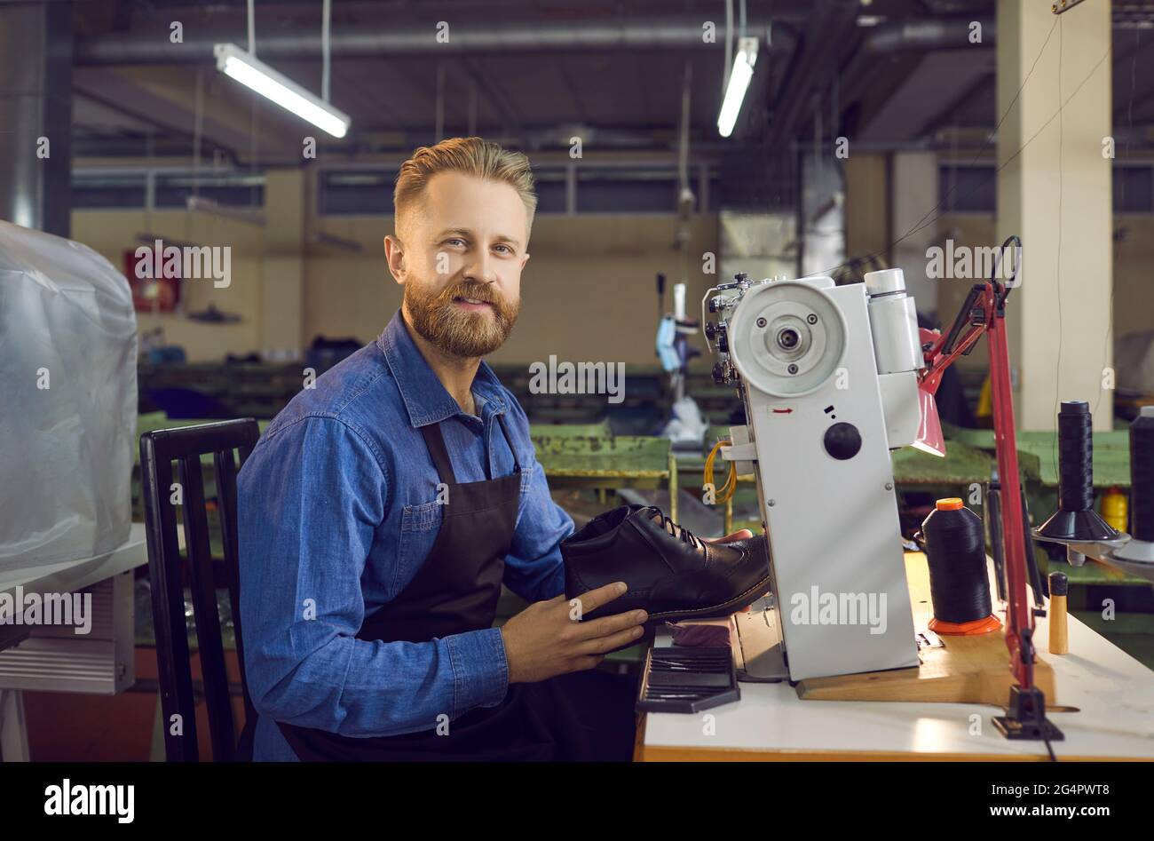 Portrait of a skilled shoe factory worker who makes men's leather shoes
