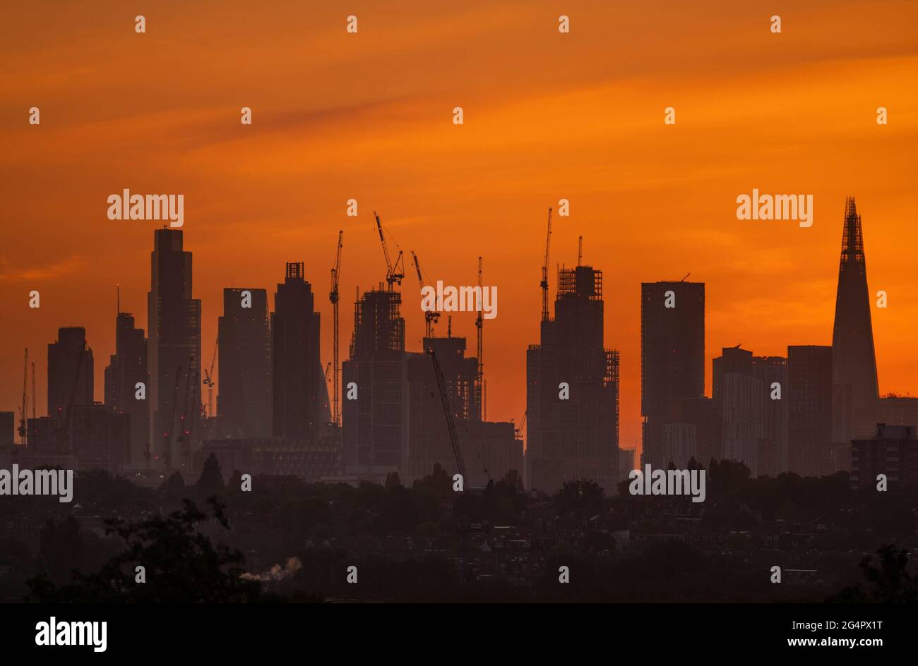Wimbledon, London, UK. 23 June 2021. The first clear sunrise with a golden sky over London since the clouded out summer solstice on 21st June. Credit: Malcolm Park/Alamy Live News Stock Photo