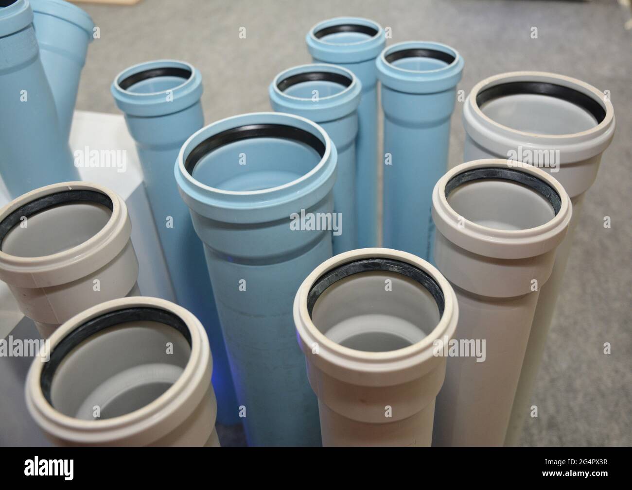 The display of plastic white and blue sewer pipes, underground drain pipes in a shop. Choosing PVC sewer drain pipes. Stock Photo