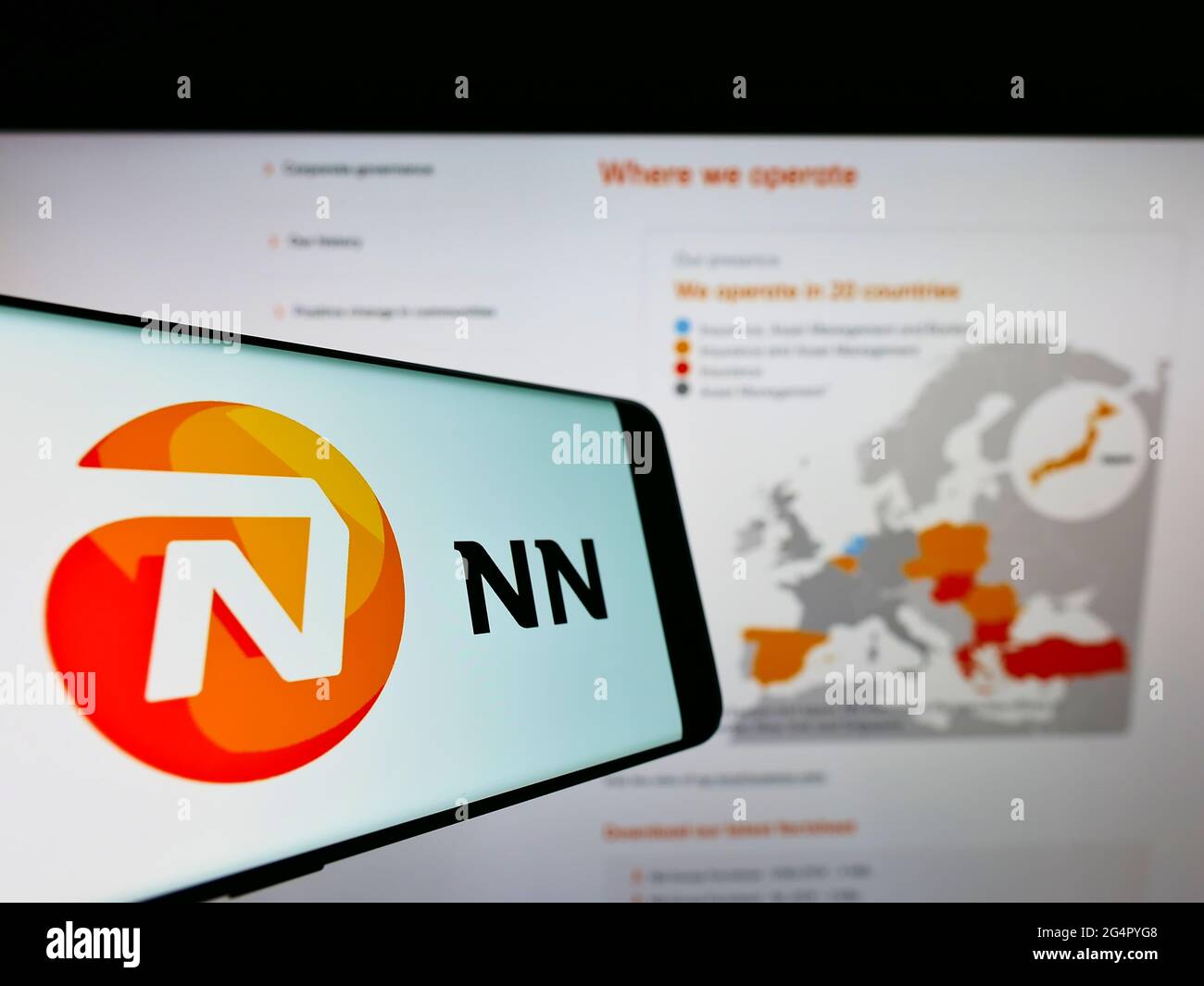 Cellphone with logo of Dutch insurance company NN Group N.V. on screen in front of business website. Focus on center-right of phone display. Stock Photo