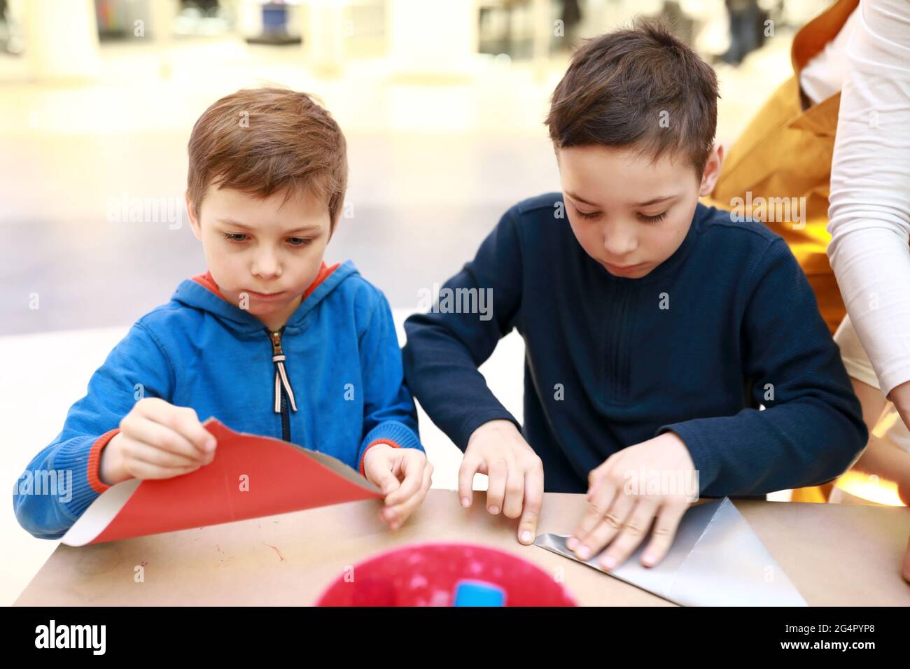 Two children make paper crafts at workshop Stock Photo - Alamy