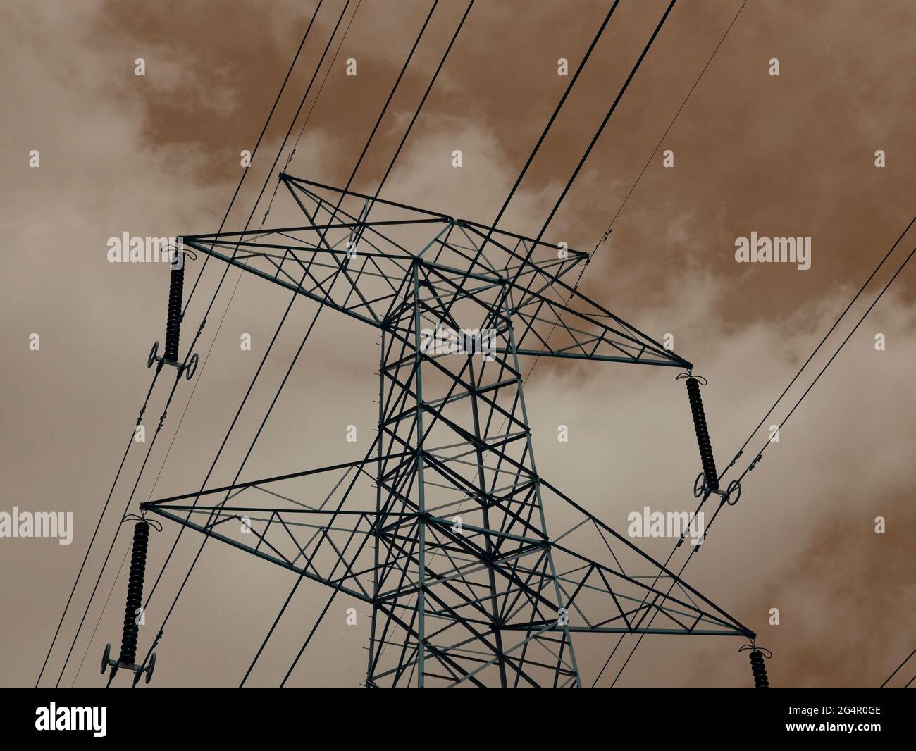 Electric power supply tower isolate on cloudy sky backdrop. Stock Photo