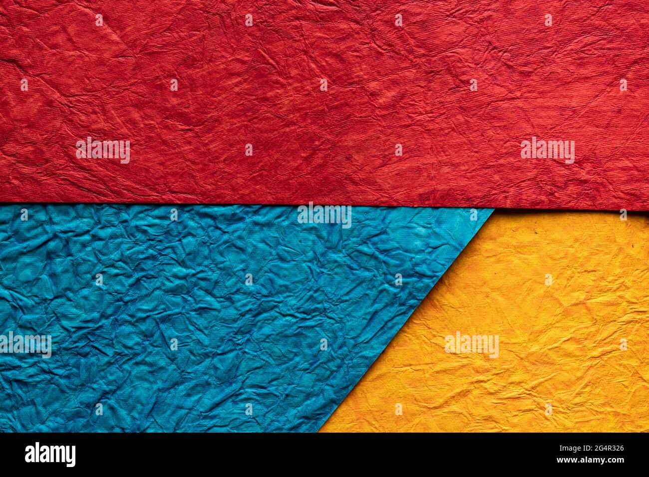 Splited Background with red, blue and yellow coloured crushed paper ...