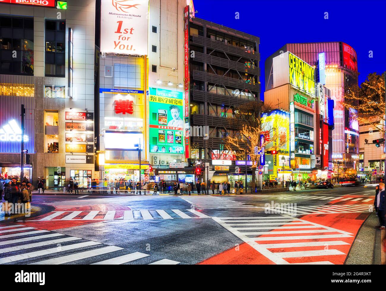 Tokyo, Japan - 31 Dec 2019: Famous Shibuya crossing urban streets intersection at sunset with bright ad lights. Stock Photo