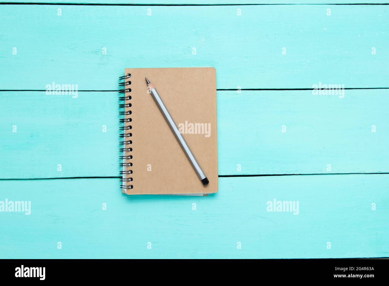 Kraft paper notepad with pencil on blue wooden table. Top view Stock ...