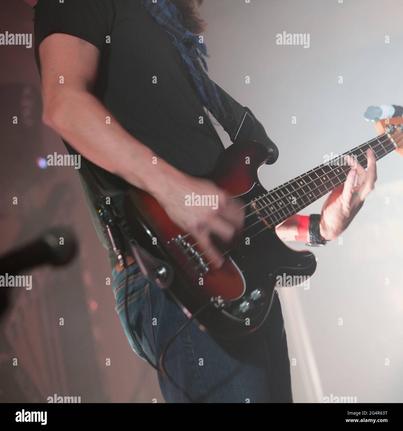 Electric bass guitar player, close-up photo with soft selective focus. Square rock music background Stock Photo