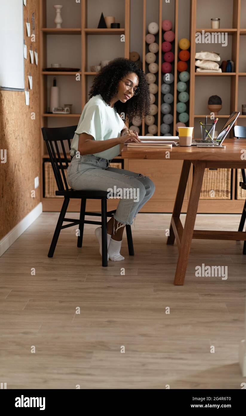 Young creative millennial african american woman designer working at office. Stock Photo