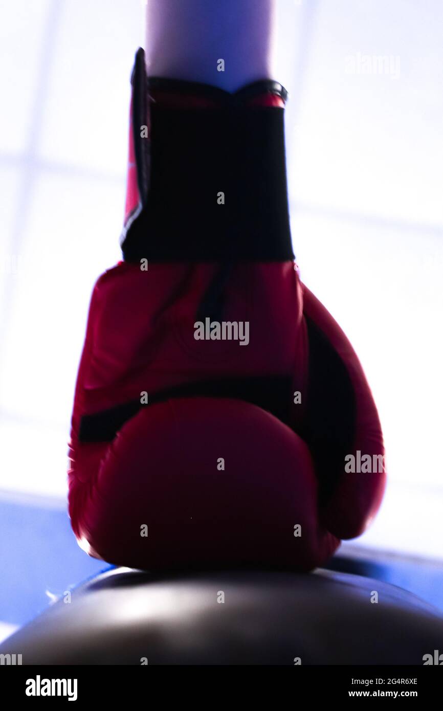 Low angle of a boxing glove hitting a punching bag under a blurred