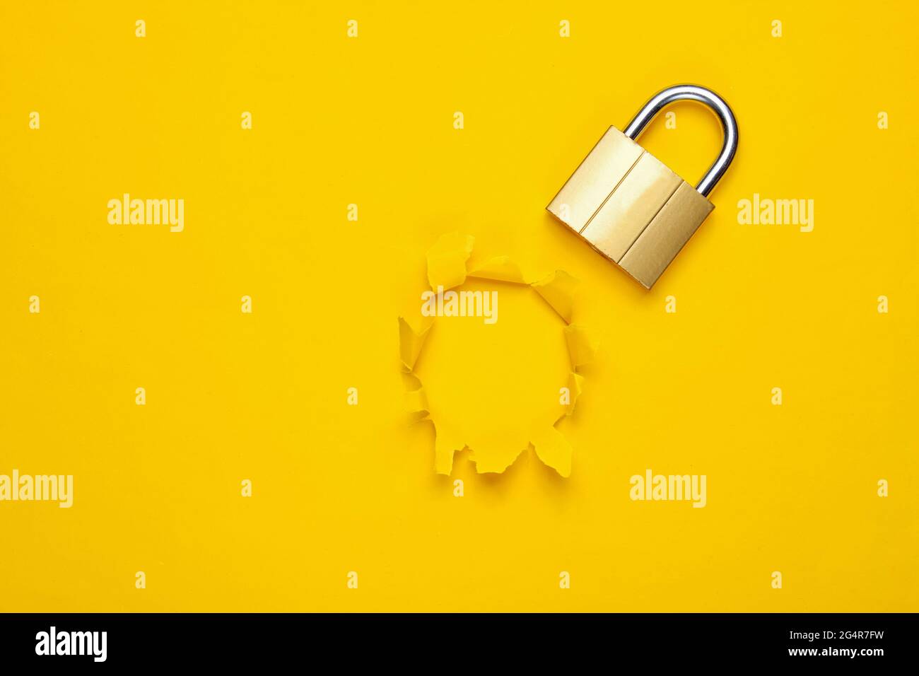 Metal lock on yellow background with torn hole. Top view Stock Photo ...