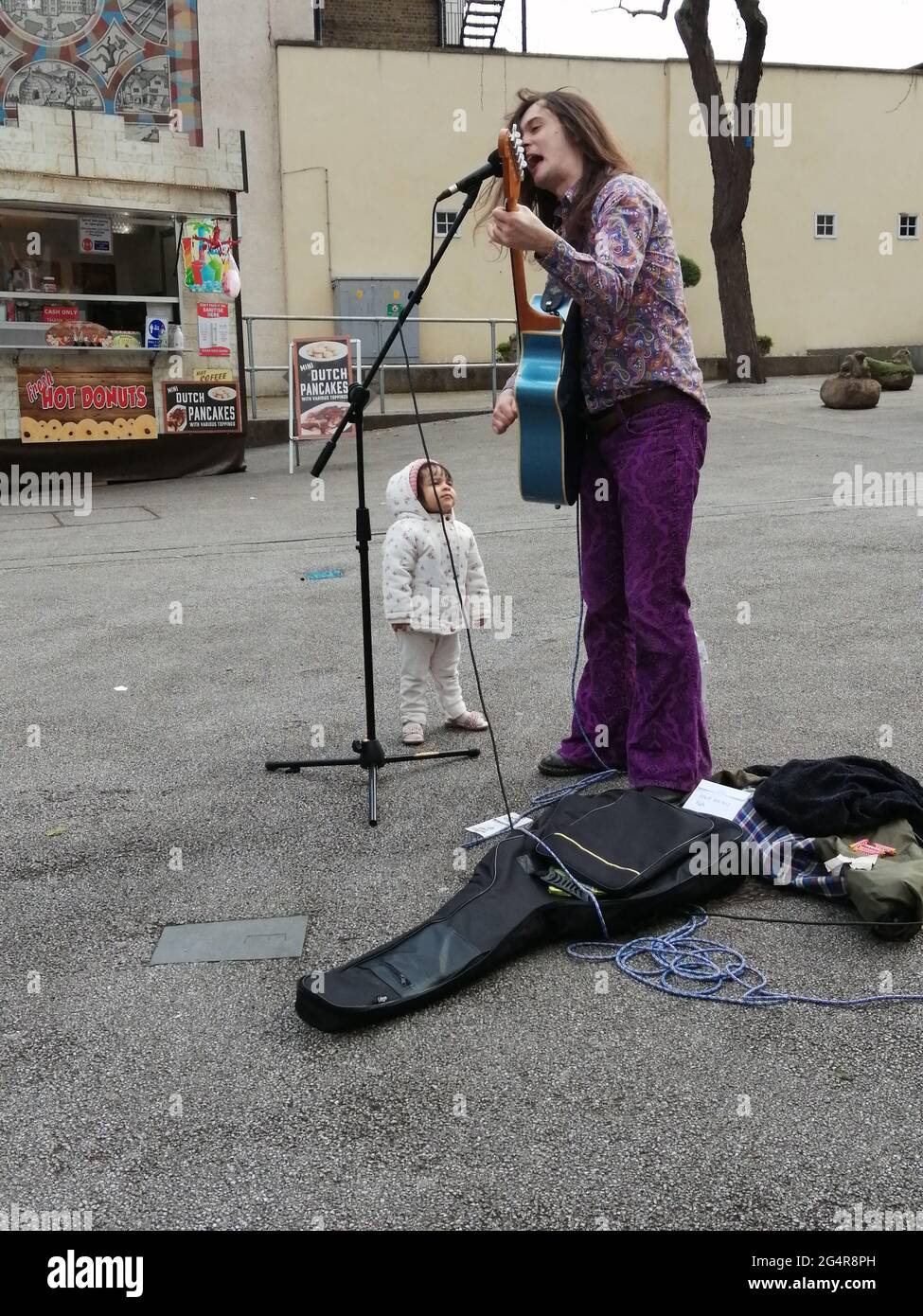 Busker and Child in Sutton High Street Stock Photo