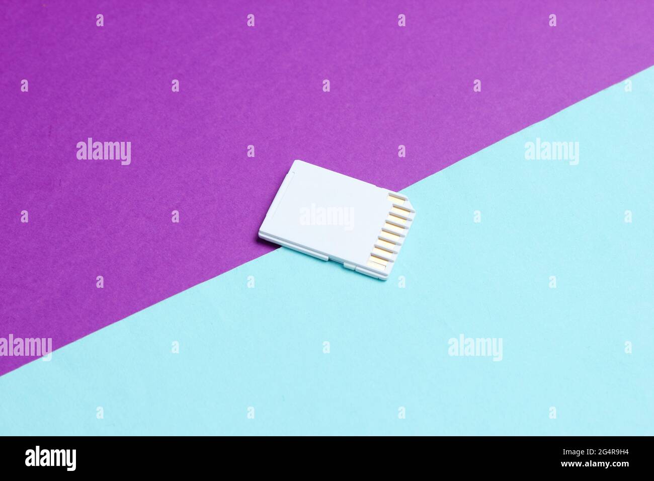 Mini sd memory card on blue purple paper background close up stock