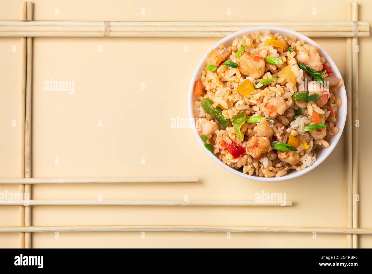 A plate of oriental fried rice with eggs, paprika, spring onion and