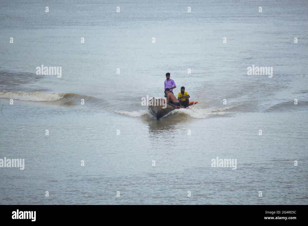 A wooden boat is running in the river Stock Photo