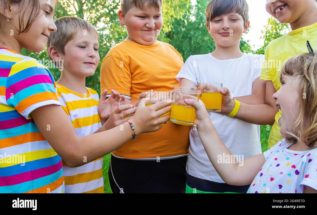 Children are drinking lemonade on the street together. Selective focus. Kids. Stock Photo