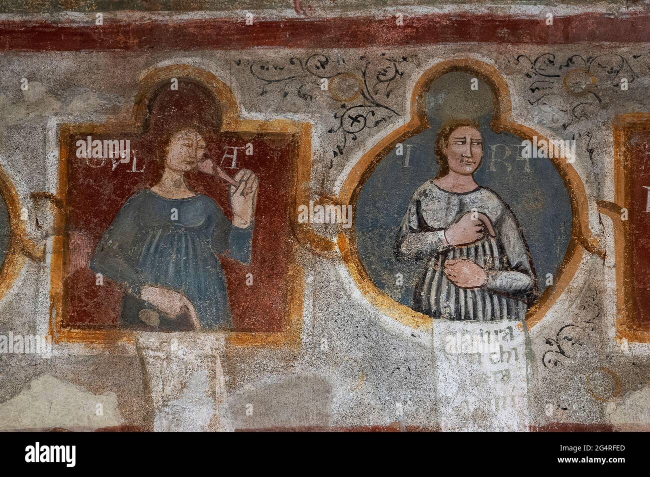 Two of Christianity’s Seven Deadly Sins, Gluttony (left) and Wrath, personified and with manicules (pointing index fingers).  Detail of early 1300s Last Judgement fresco in the Chiesa di Santa Maria del Tiglio, Gravedona, Lombardy, Italy. Stock Photo