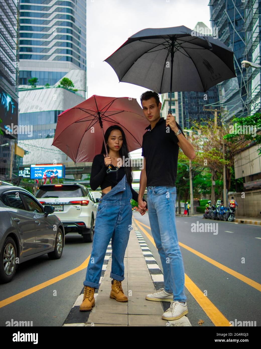Couple in city with umbrellas Stock Photo - Alamy
