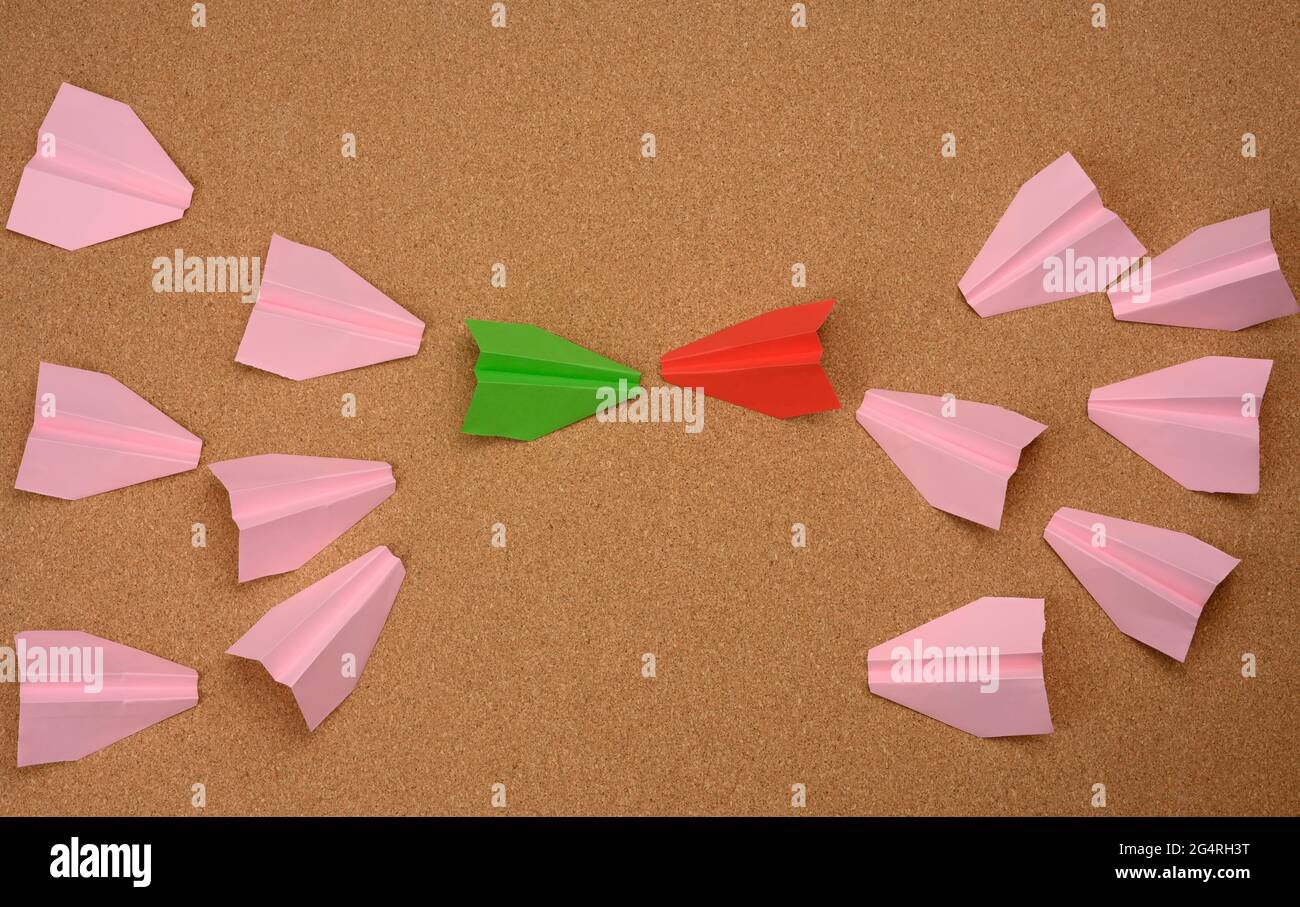 two large groups of paper airplanes on a brown background. Conflict of interest, quarrel and confrontation concept Stock Photo