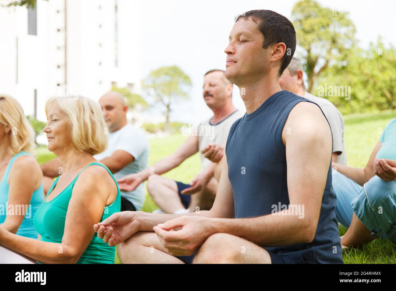 Group of People practicing yoga outside Stock Photo