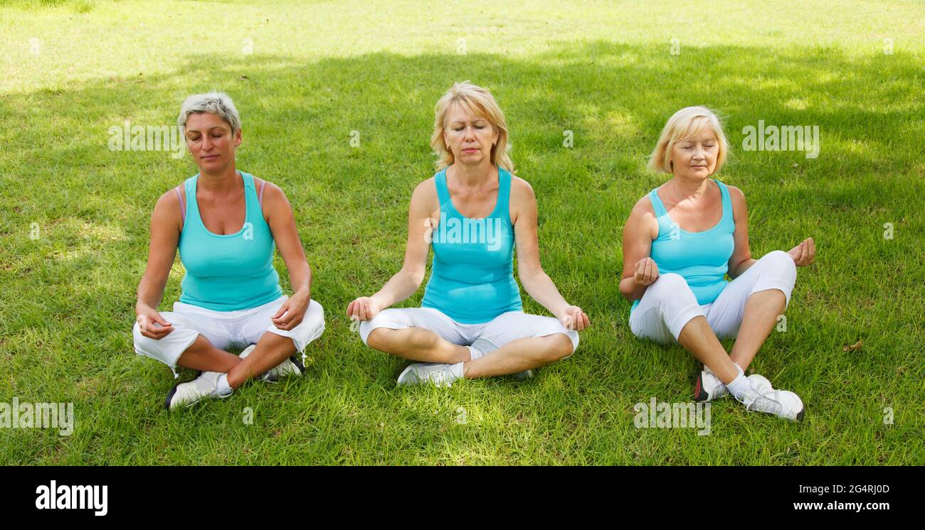 Group of women practicing yoga outside Stock Photo