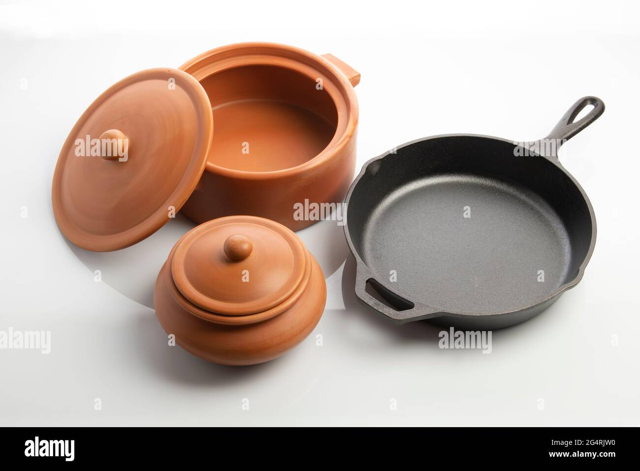 https://c8.alamy.com/comp/2G4RJW0/cast-iron-skillet-and-clay-pots-isolated-on-white-background-2G4RJW0.jpg