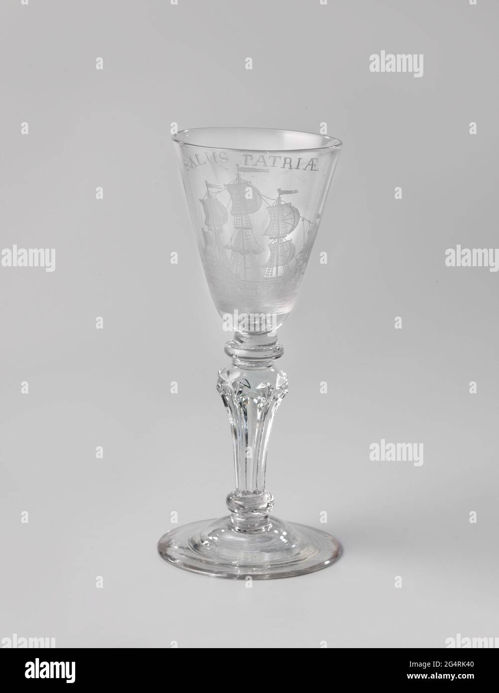 Wine glass with a three-master and the inscription: Salus Patriæ. Wine glass of clear, colorless glass, with a graved representation of a three-master and the inscription: Salus Patriæ. Stock Photo