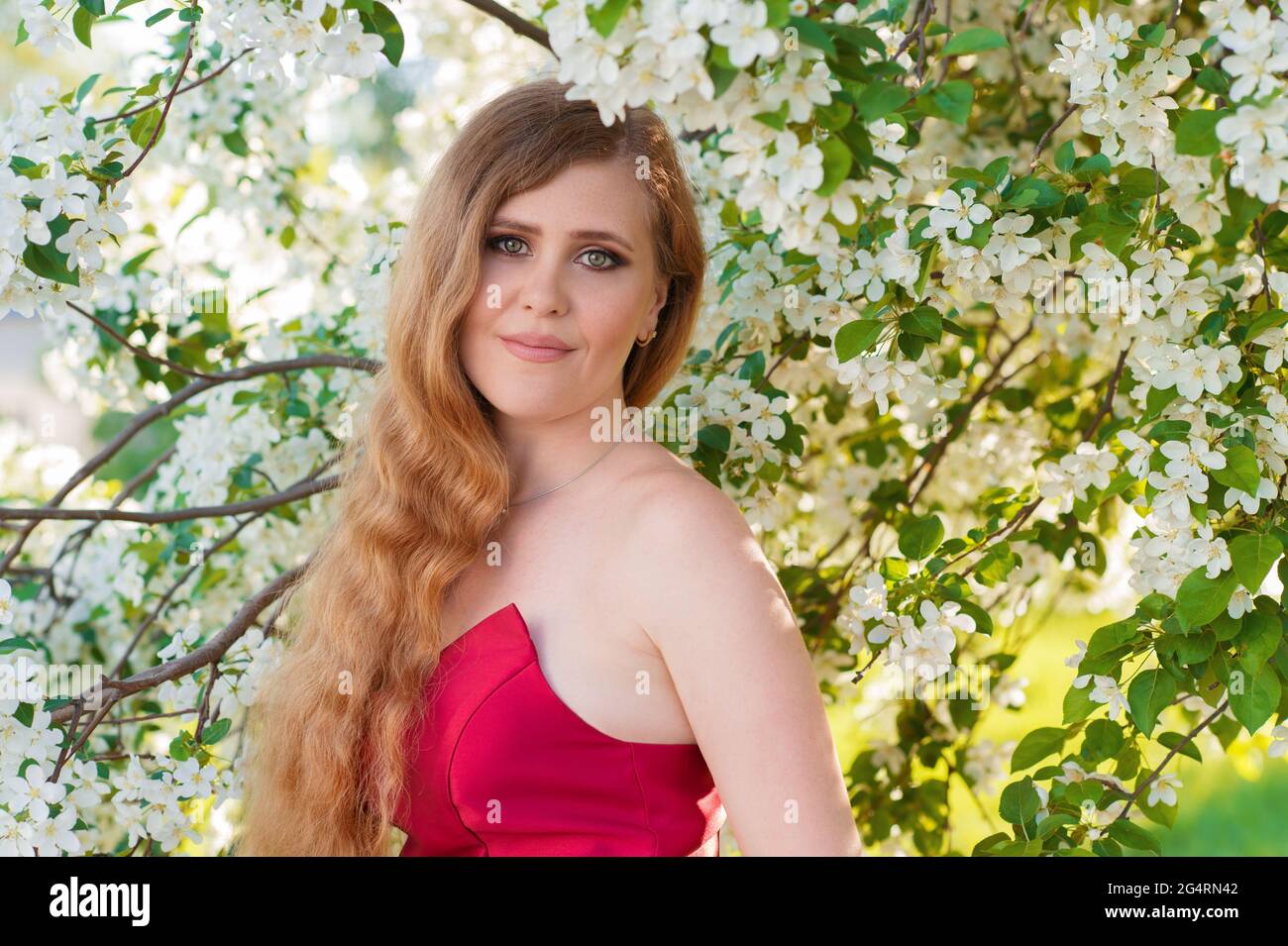 portrait smiling woman in blooming gardens in red dress Stock Photo - Alamy