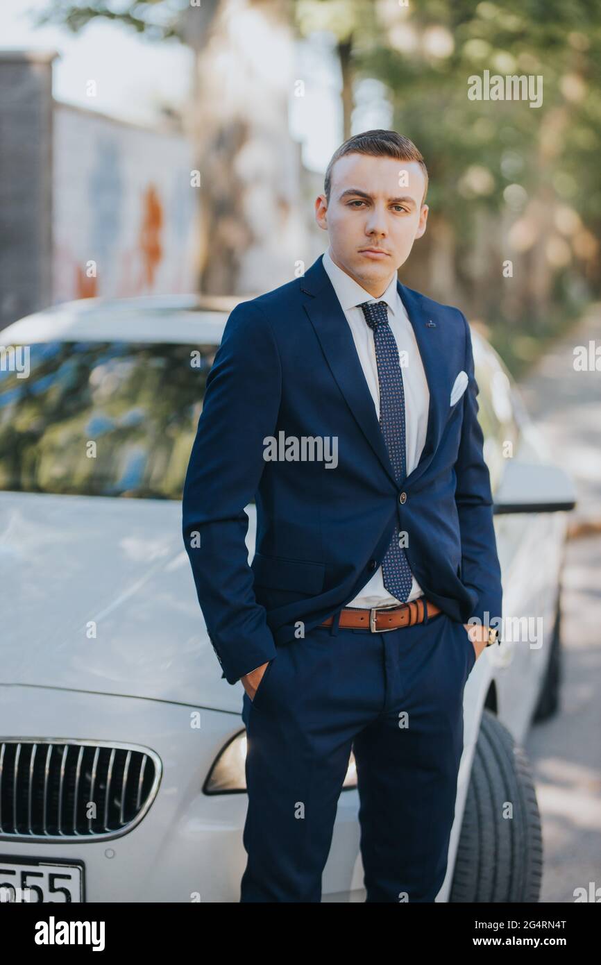 Caucasian handsome young businessman in a suit and tie standing outdoor ...