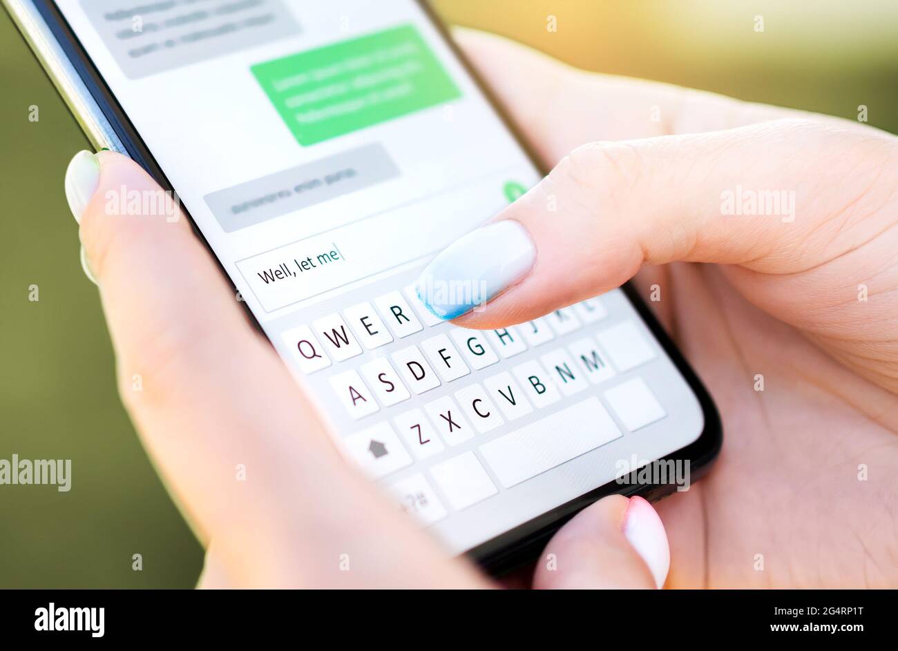 Text message with mobile phone. Woman texting sms with smartphone Catfish or digital scam. Screen keyboard in instant messaging chat. Macro close up. Stock Photo