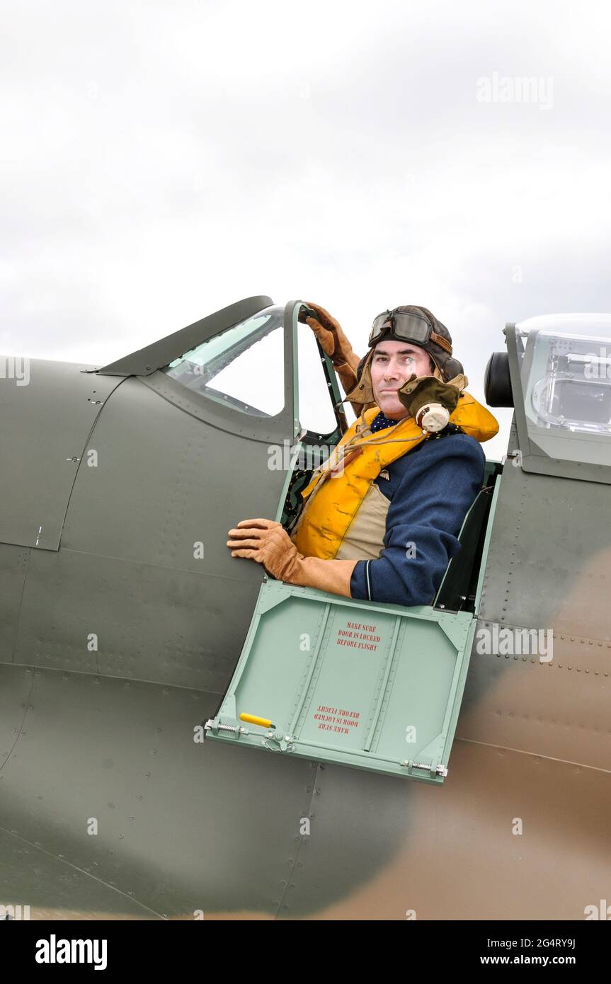 Re-enactor in period fighter pilot clothing in the cockpit of a Spitfire Mk.I. Second World War Battle of Britain era flying clothing and equipment Stock Photo
