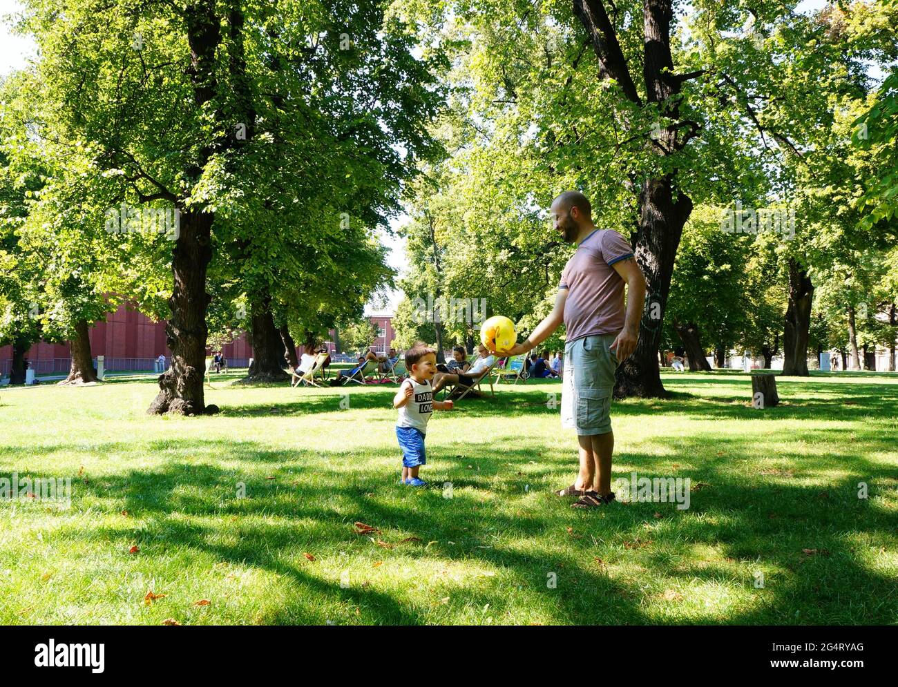POZNAN, POLAND - Oct 20, 2015: Man and a toddler boy standing on grass at a park Stock Photo