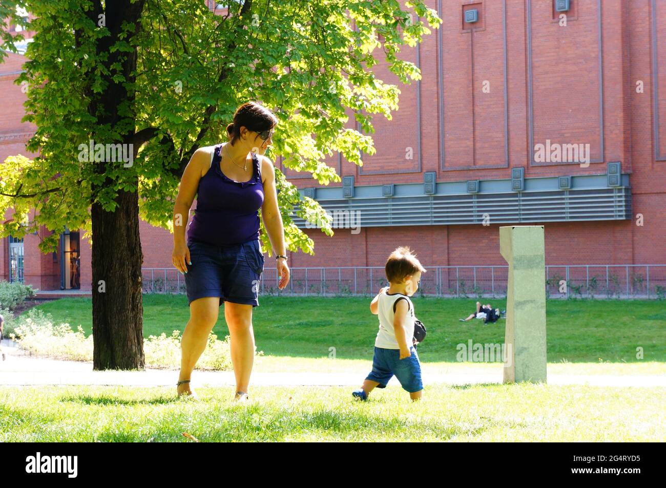 POZNAN, POLAND - Oct 20, 2015: Woman and toddler boy on green grass at a park Stock Photo