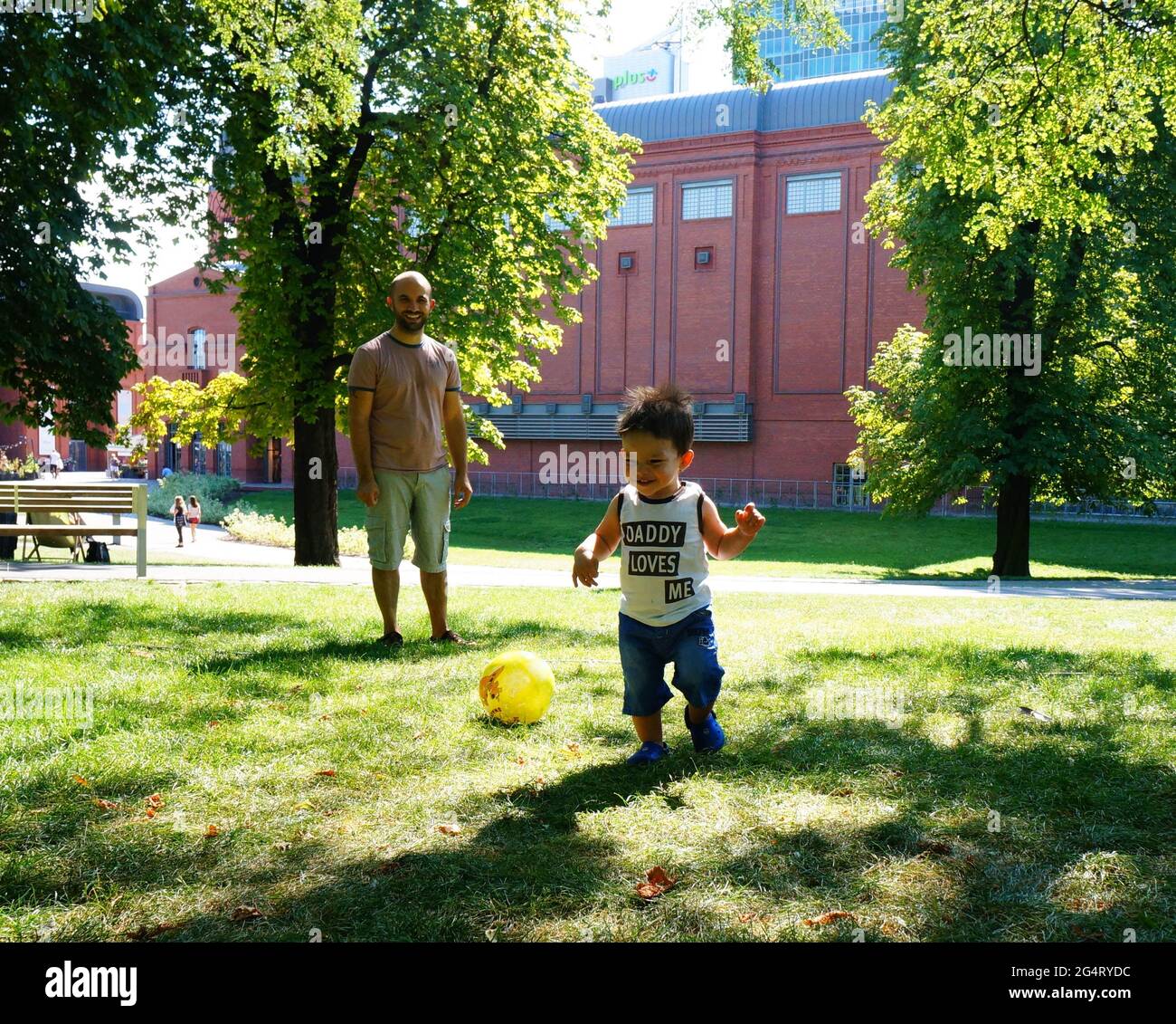 POZNAN, POLAND - Oct 20, 2015: Man and a toddler boy standing on grass at a park Stock Photo