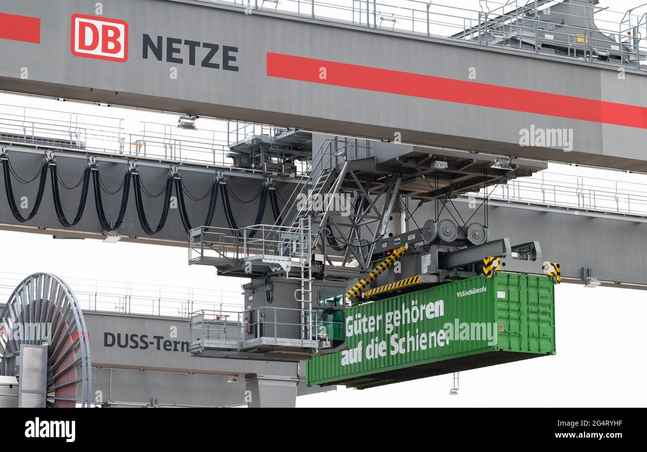 Lehrte, Germany. 23rd June, 2021. A container with the inscription 'Güter gehören auf die Schiene' ('Goods belong on the rails') is loaded at the MegaHub container railway station in the Hanover region. Deutsche Bahn has officially opened a new type of container railway station. At the so-called Megahub, containers are loaded from trucks onto trains. Credit: Julian Stratenschulte/dpa/Alamy Live News Stock Photo