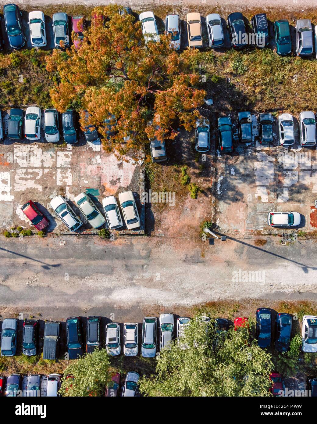 Aerial view of an abandoned junkyard with vehicles parked in a parking