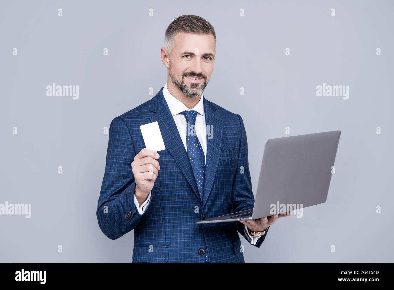 confident businessman man in businesslike suit hold computer and credit card, payment online Stock Photo