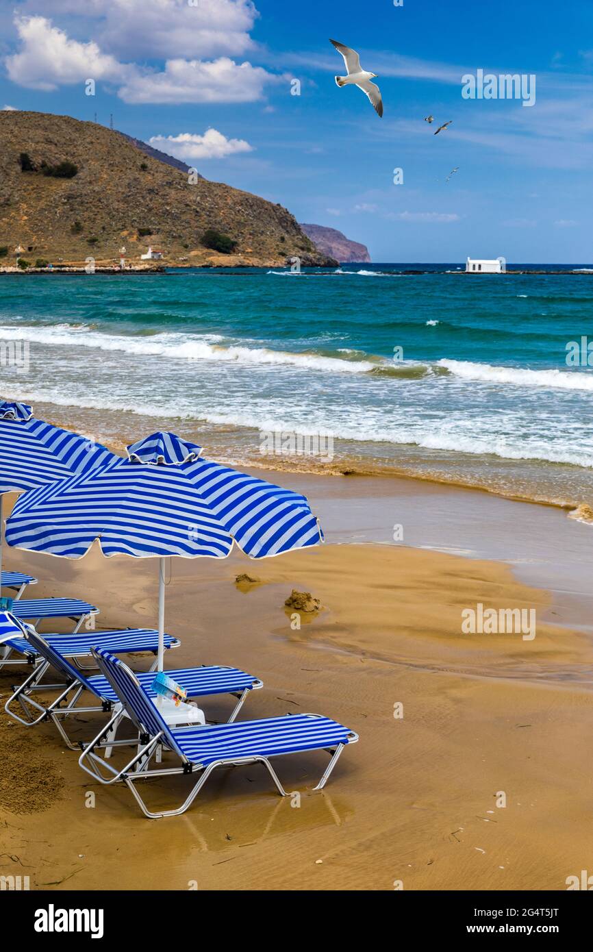 View of sunbeds awaiting tourists at the Greek island resort of Georgioupolis on Crete north coast. Georgioupoli is a resort village and former munici Stock Photo