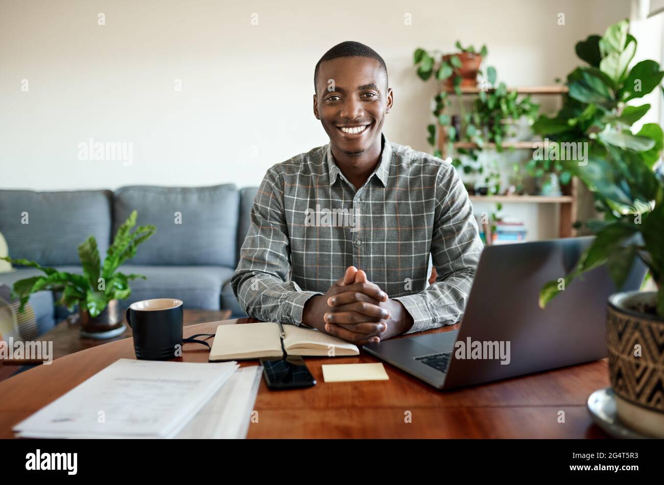 Smiling young African businessman working remotely from home Stock Photo