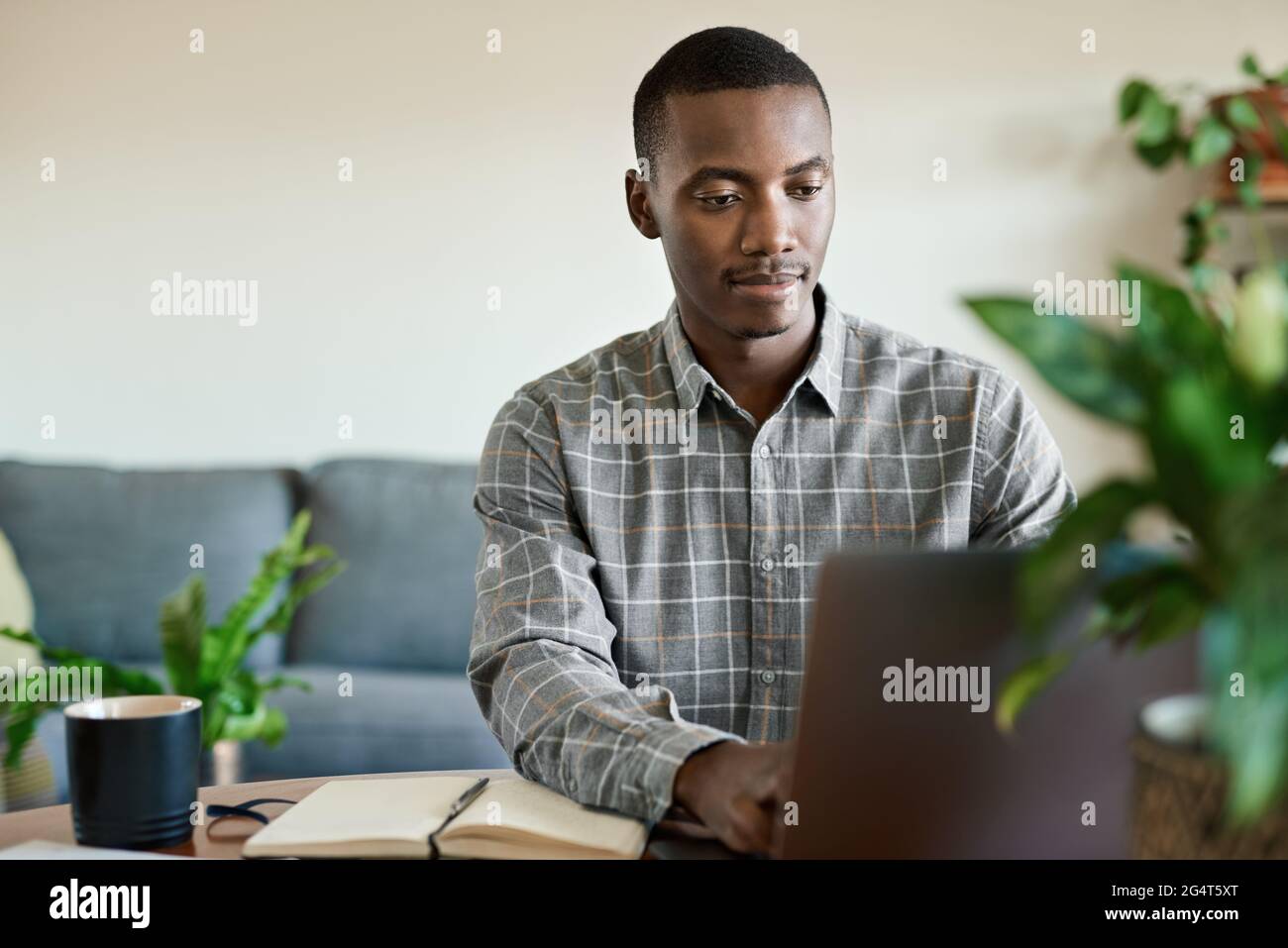Young African businessman working remotely from home Stock Photo