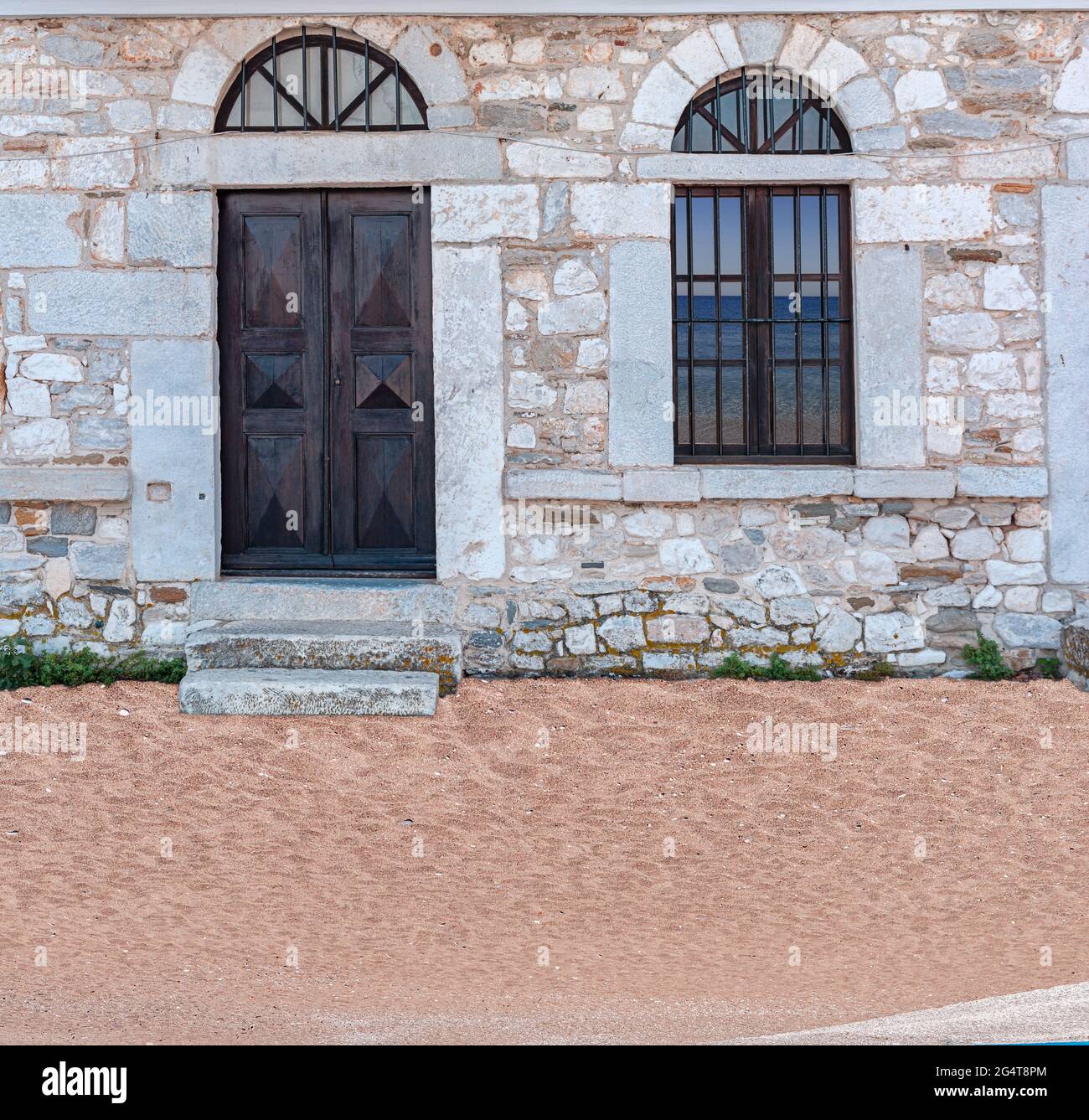 Old architecture stone house with black wooden door and window ...