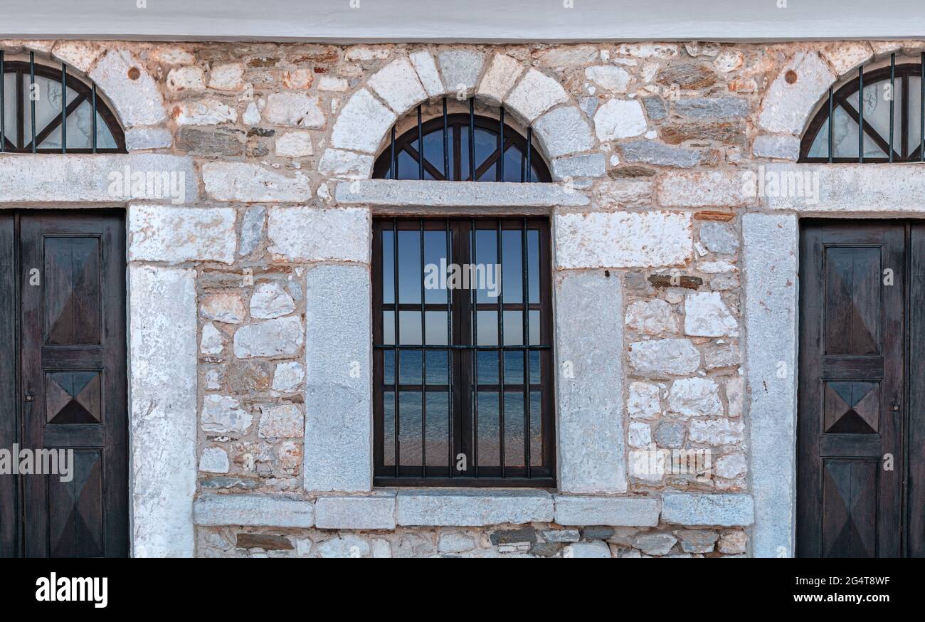 Old architecture stone house with blue sea reflection on windows Stock ...