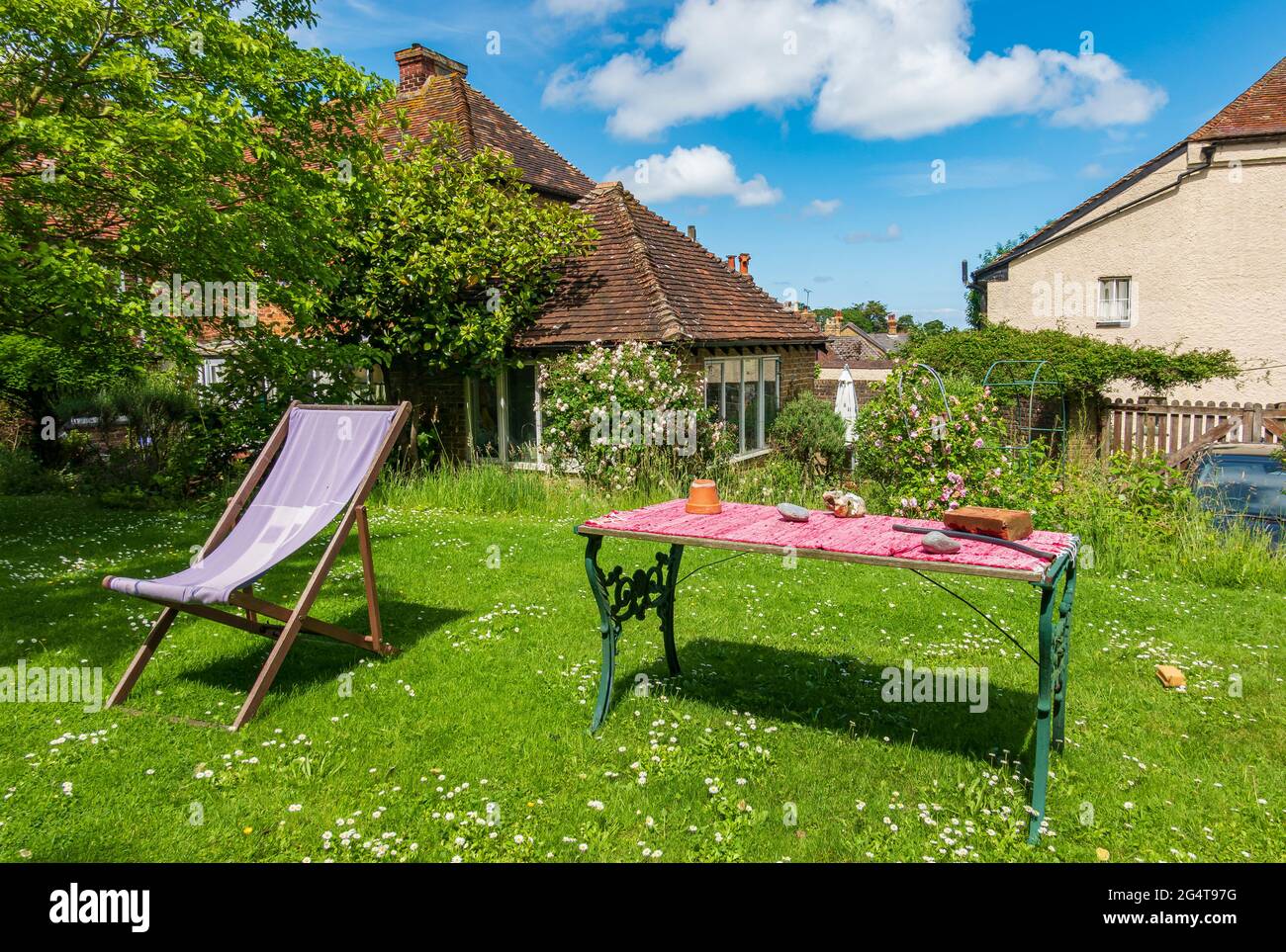 Cottage garden with deckchair and daisies in the lawn, Kent, UK Stock Photo