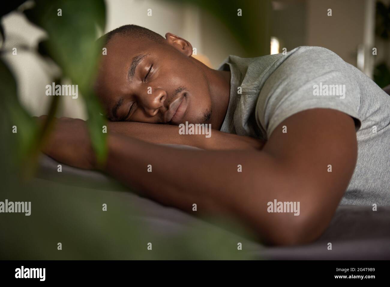 Young African man sleeping in his bed at home Stock Photo